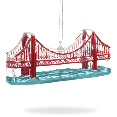Hand-painted glass ornament in the shape of the Golden Gate Bridge with a red and white color scheme, suspended by a string.