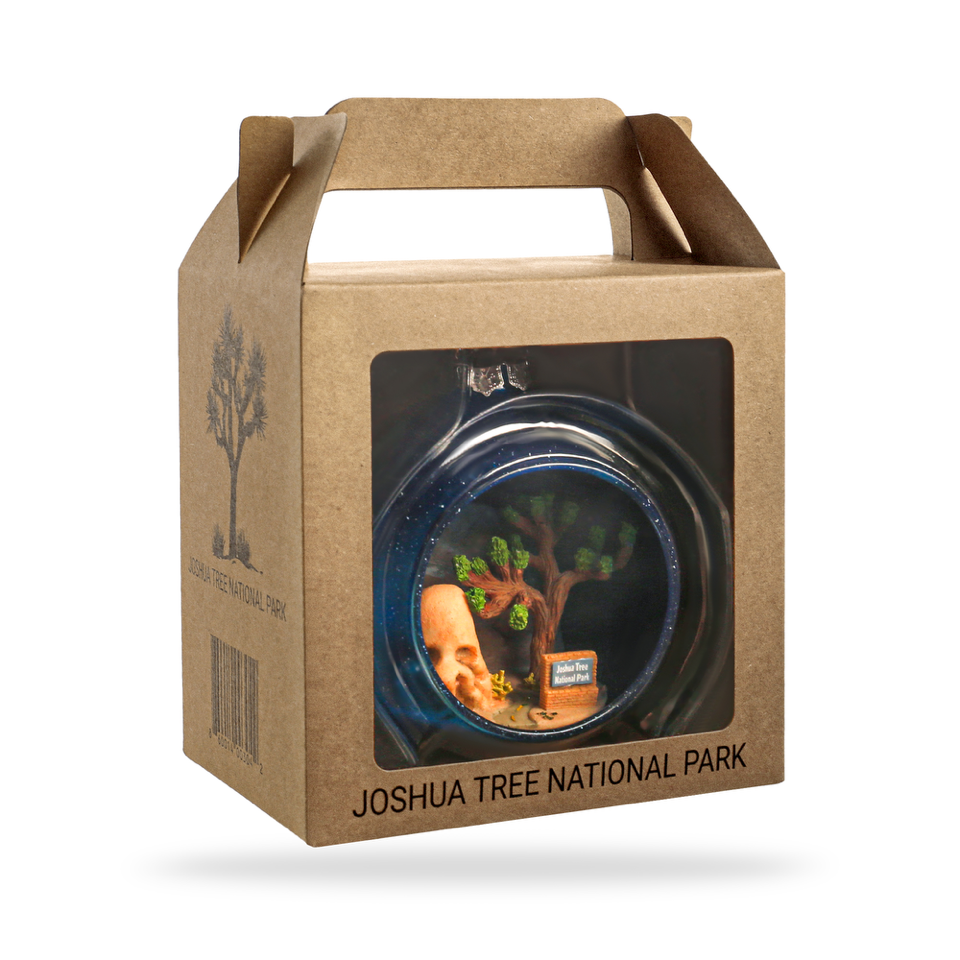 Cardboard packaging with a window displaying a small model of a Joshua Tree, branded 'Joshua Tree National Park'.