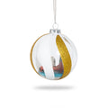 Clear Christmas ornament with gold glitter section and scenic view inside on a white background