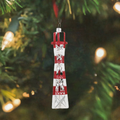 Sutro Tower glass ornament hanging on Christmas tree against skyline lights.